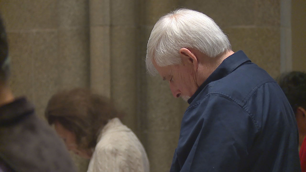 Church member prays during Saturday evening mass at Cathedral of St. John Berchmans.jpg